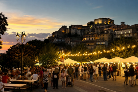 Panorama estivo dei Castelli Romani con borghi illuminati durante una festa di agosto.