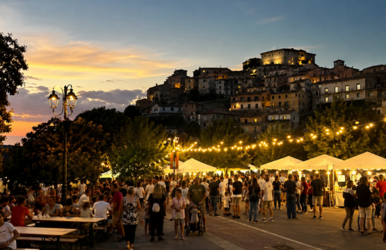 Panorama estivo dei Castelli Romani con borghi illuminati durante una festa di agosto.